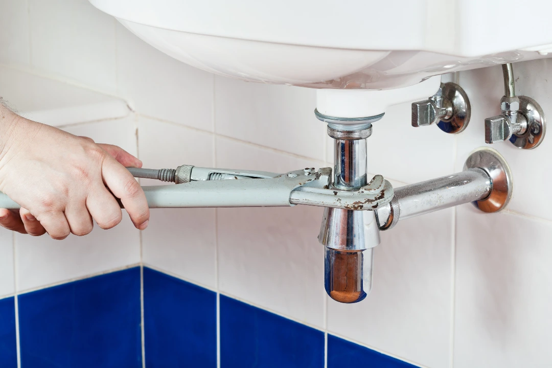 Plumber fix sink drain with pipe-wrench