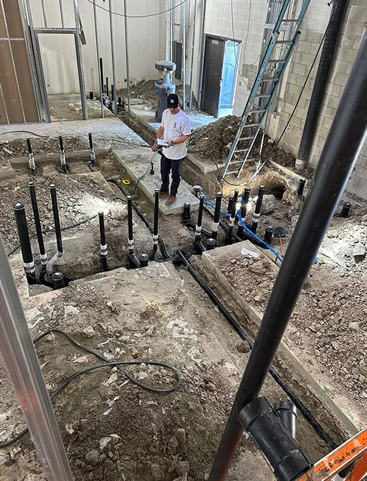 A man stands in a room filled with numerous pipes, showcasing an industrial environment and complex infrastructure A man stands in a room filled with numerous pipes, showcasing an industrial environment and complex infrastructure